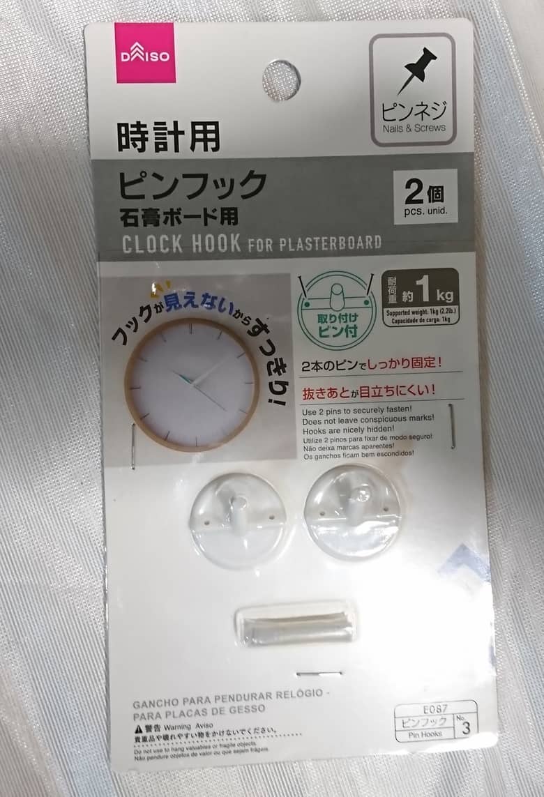 ダイソー時計用ピンフック石膏ボード用の包装を開けていない状態。フックが２個、その下にピンが入っている。